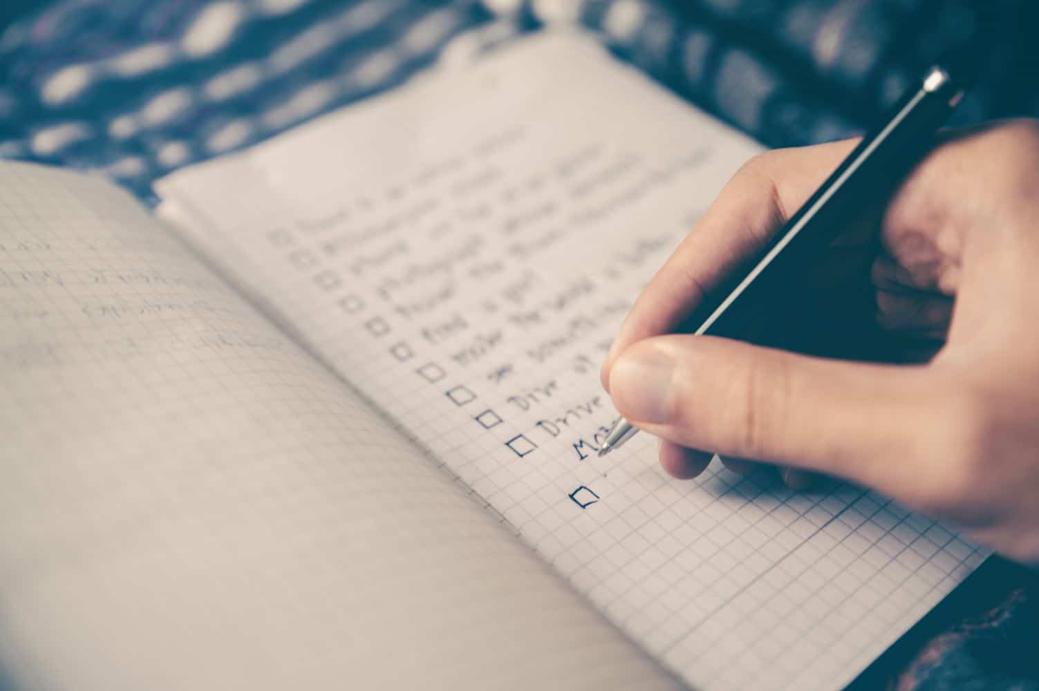 Hand schreibt To-Do-Liste